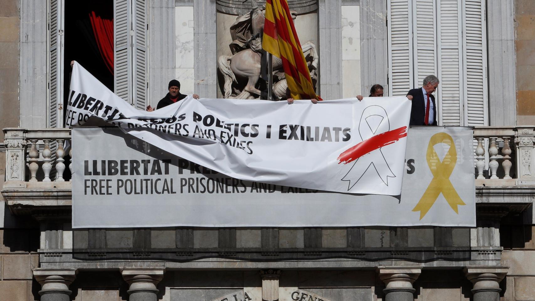 Momento en el que la pancarta con el lazo amarillo es sustituida por una similar con uno blanco con una franja roja.