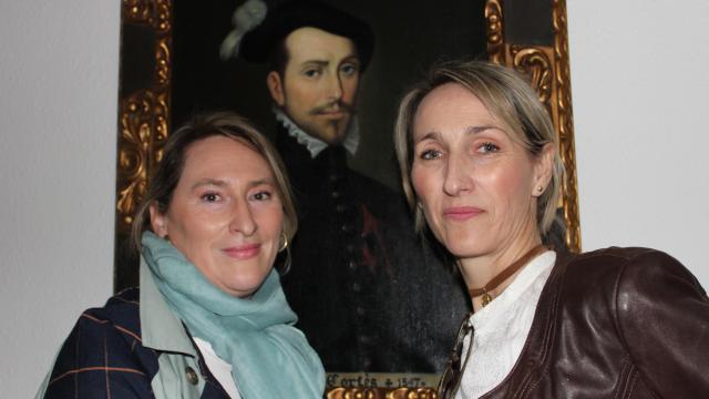 Susana Cortés y Virginia Cortés junto a su antepasado, en un retrato, el conquistador Hernán Cortés.