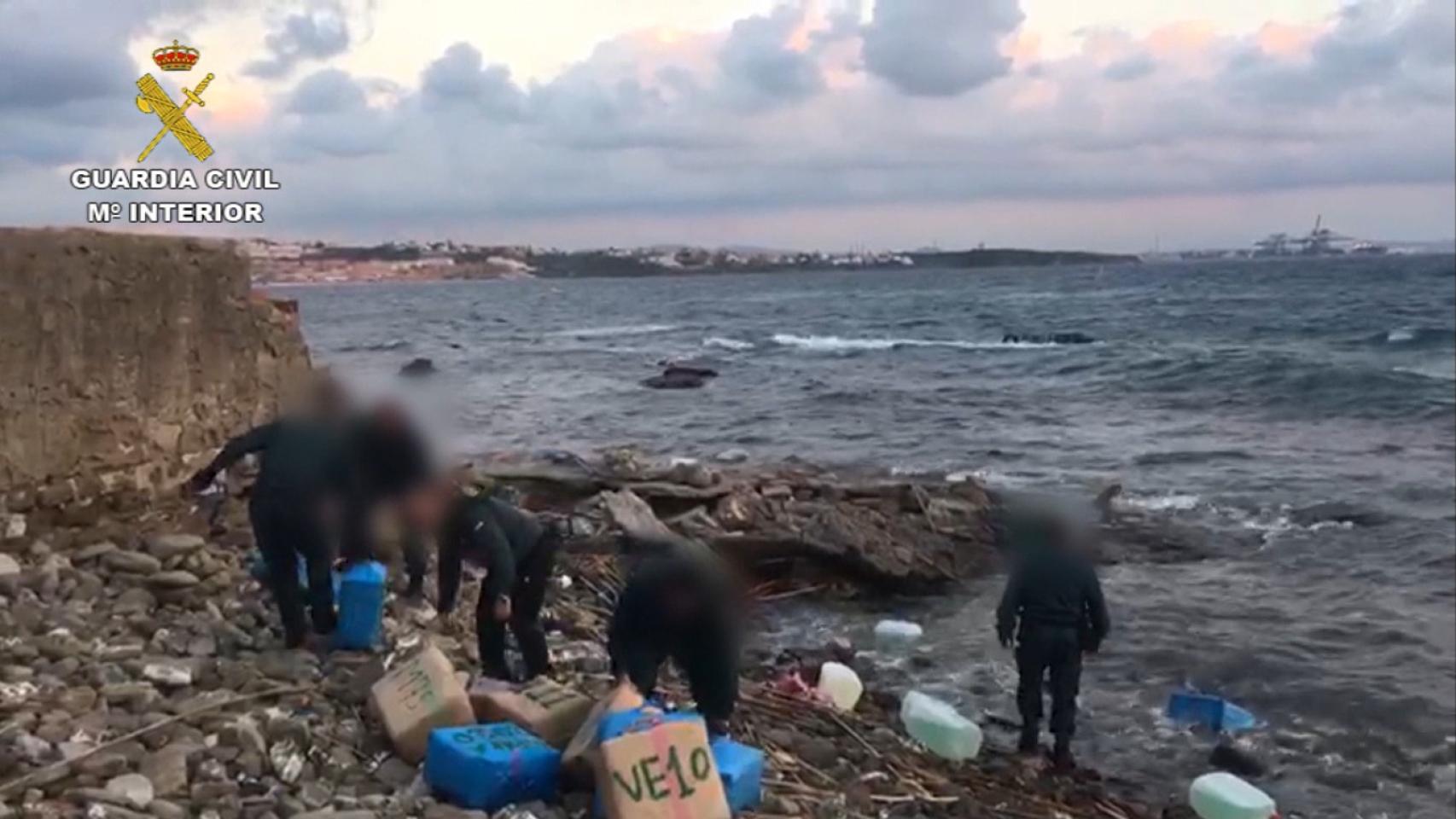 Agentes de la Guardia Civil se incautan de fardos de hachís.