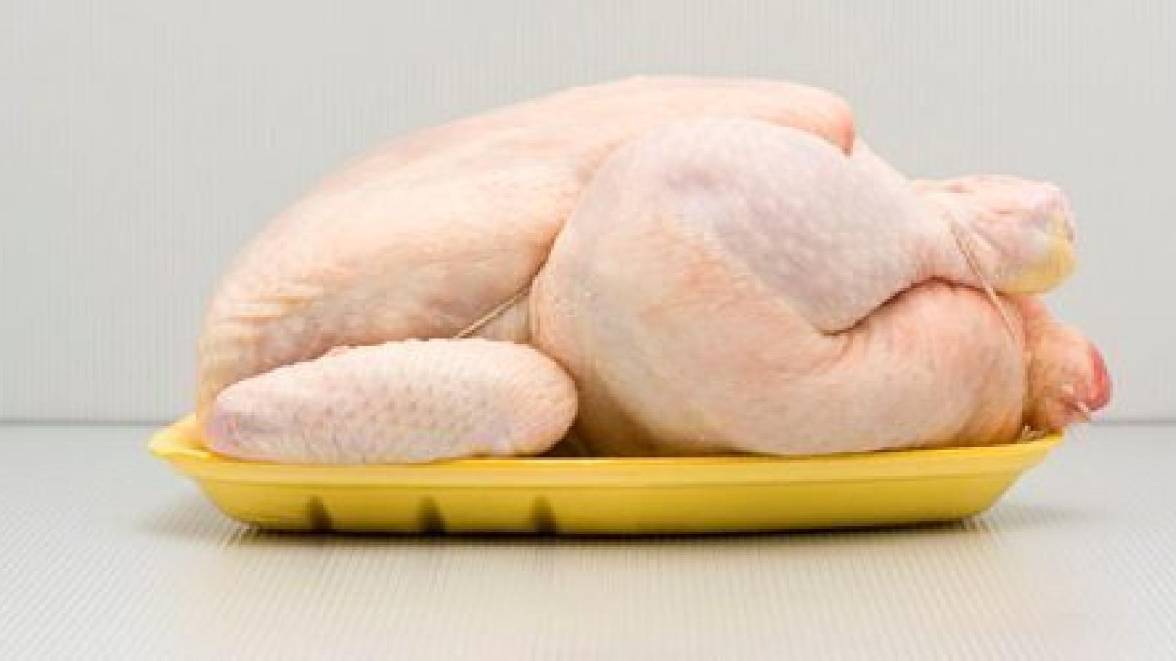 Un pollo de corral en una bandeja de supermercado.