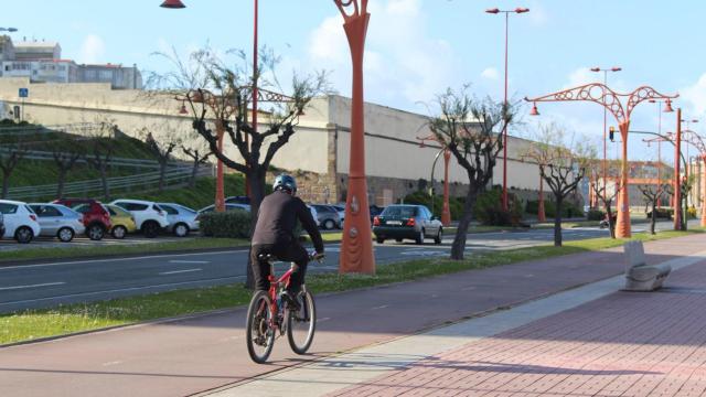Un ciclista circula por el carril bici del paseo marítimo.