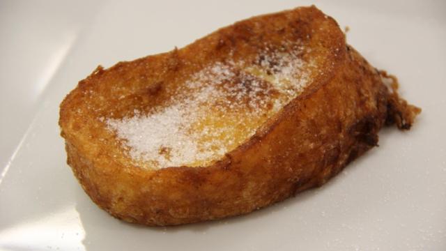 Una torrija espolvoreada con azúcar.