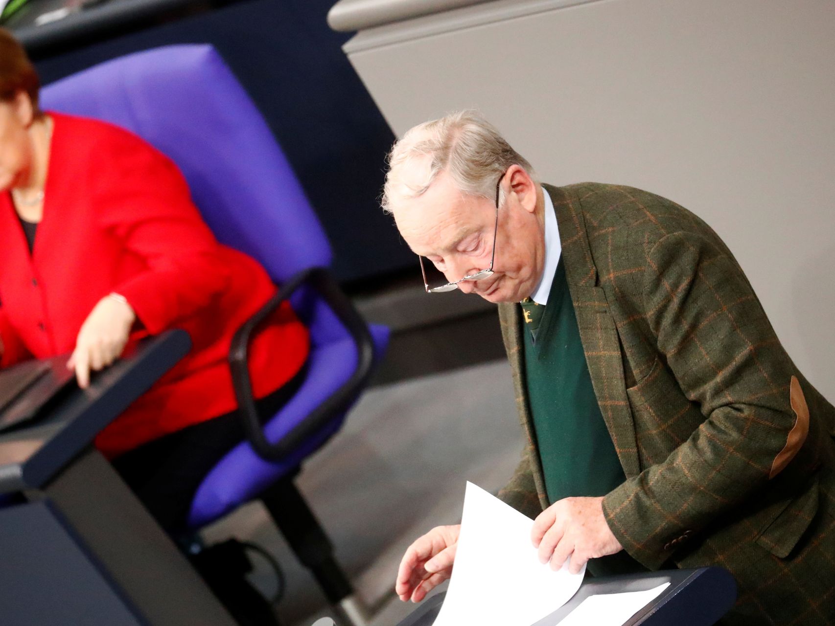 Alexander Gauland, líder de la AfD, habla desde la tribuna del Bundestag junto a Angela Merkel.