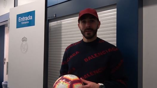 Benzema junto al balón con el que anotó el hat-trick