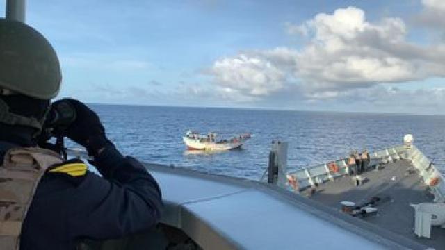 Un miembro de la dotación de la Navarra estudia los movimientos del barco tomado por los piratas.