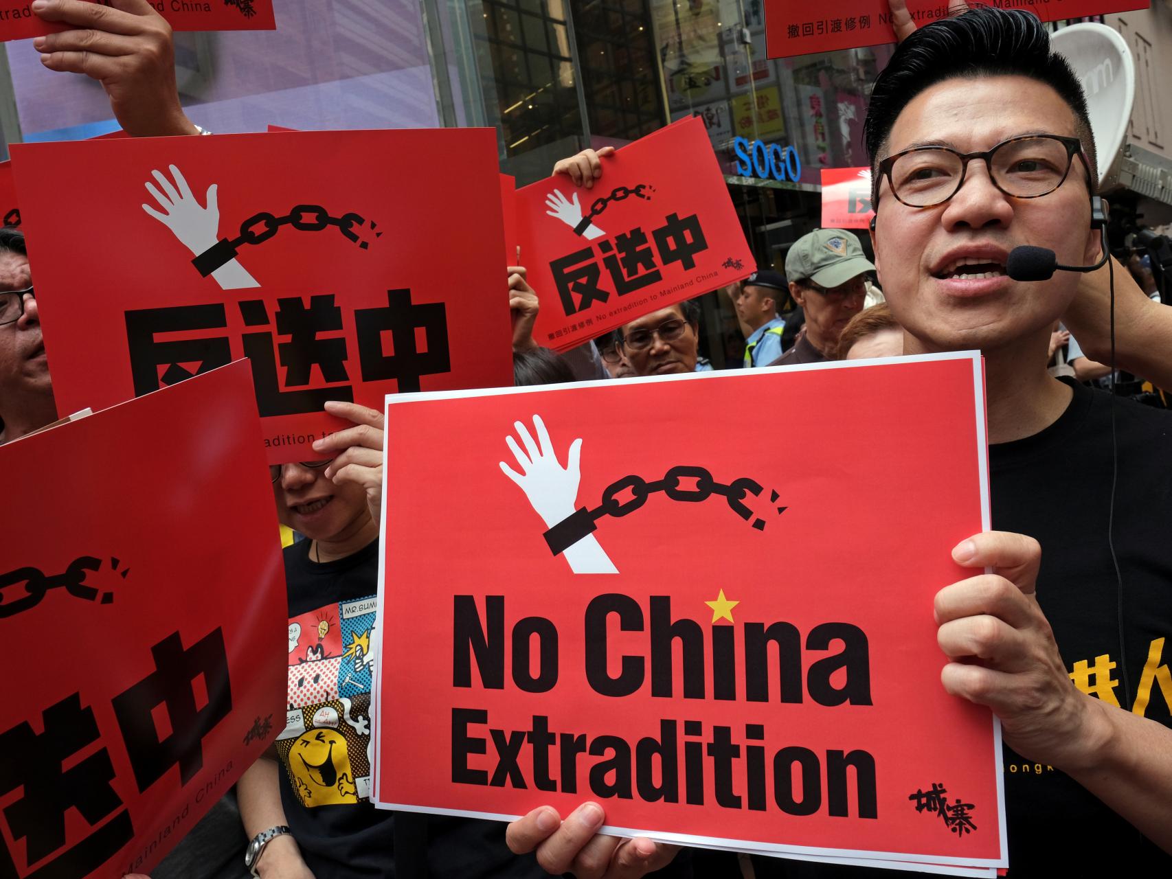 Uno de los manifestantes porta una pancarta en contra de la extradición.
