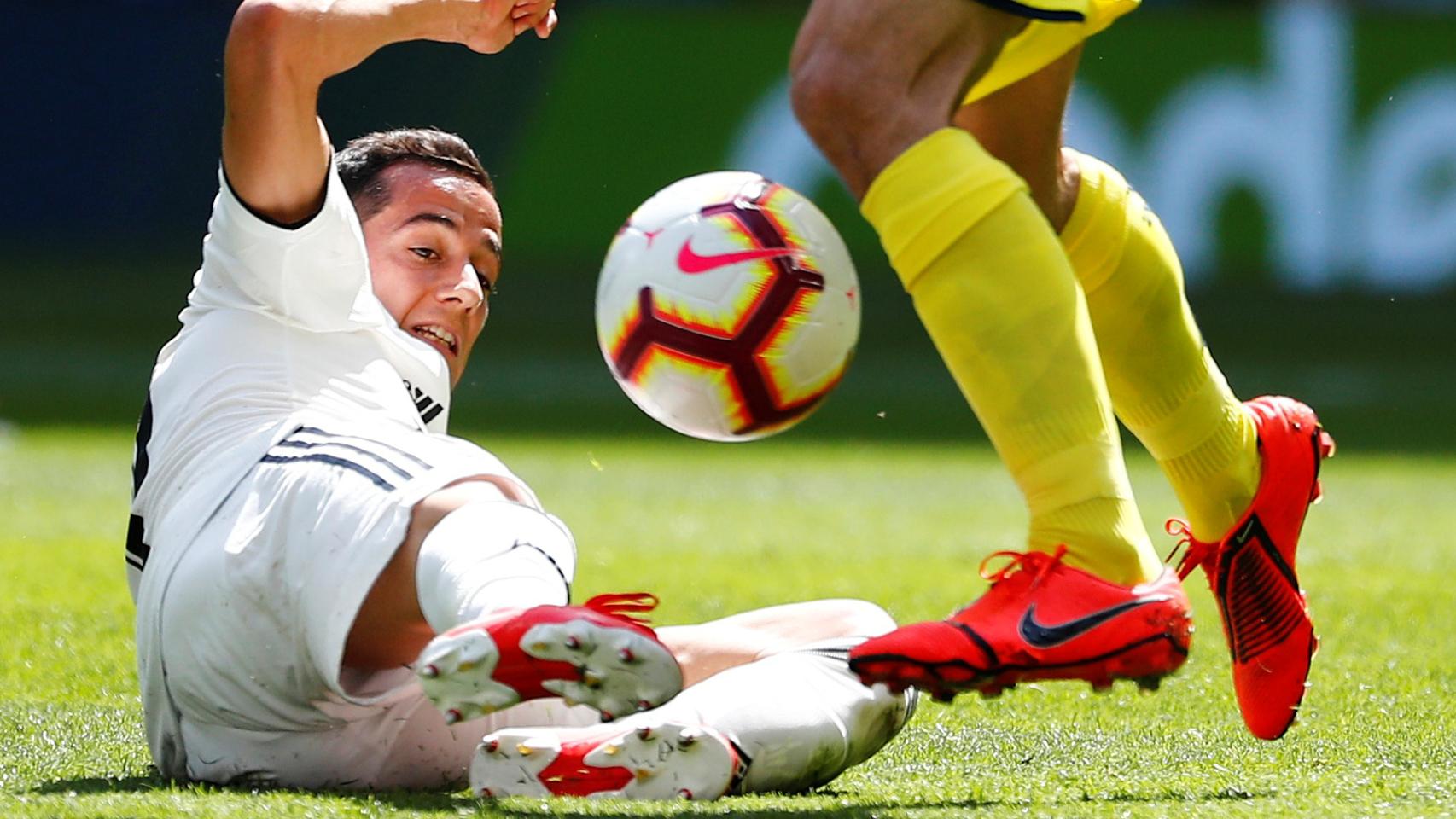 Lucas Vázquez intenta robar el balón desde el suelo