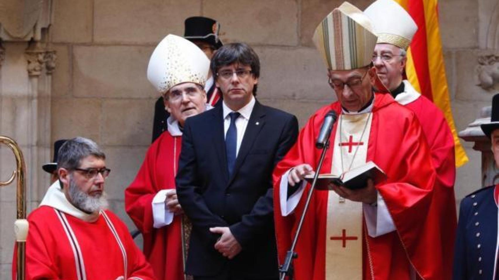 Puigdemont, escuchando al cardenal de Barcelona, Juan José Omella, en una imagen de archivo.
