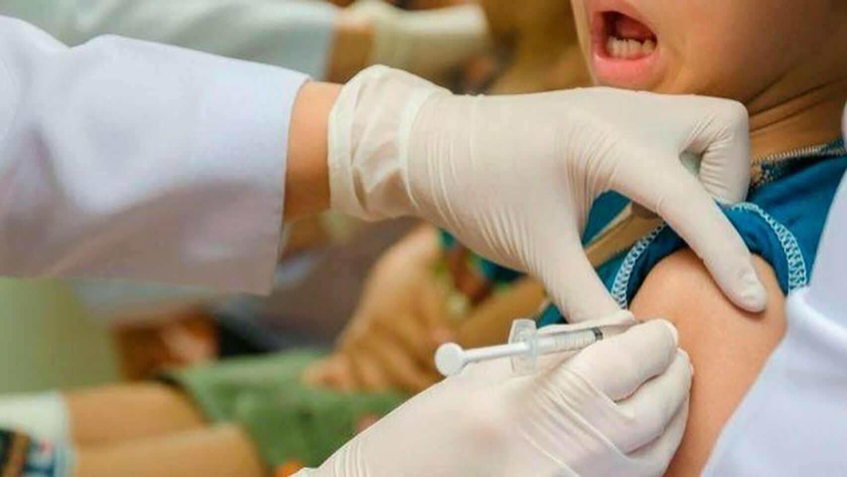 Enfermero vacunando a un niño.