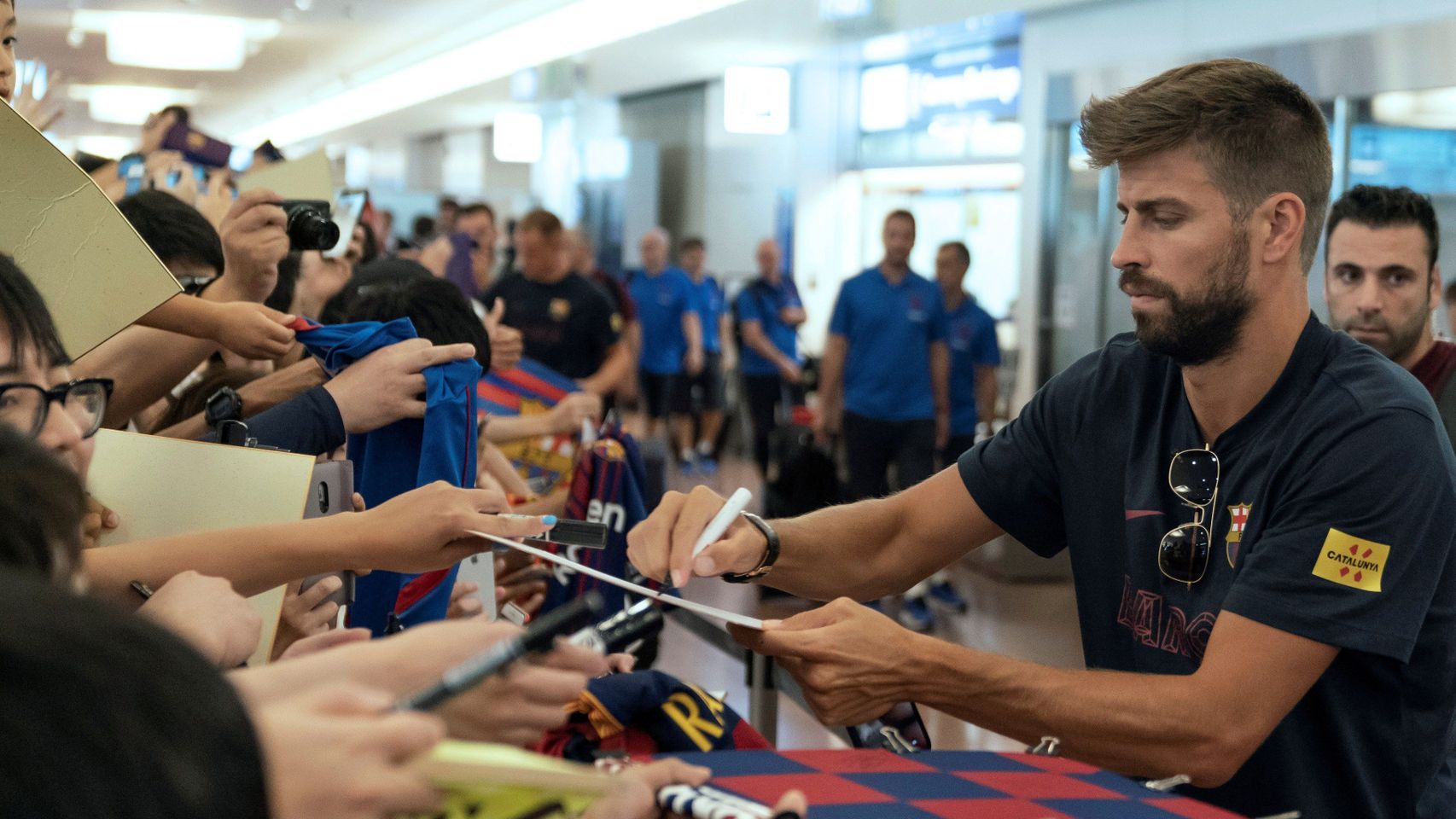 Piqué firmando autógrafos en la llegada a Japón
