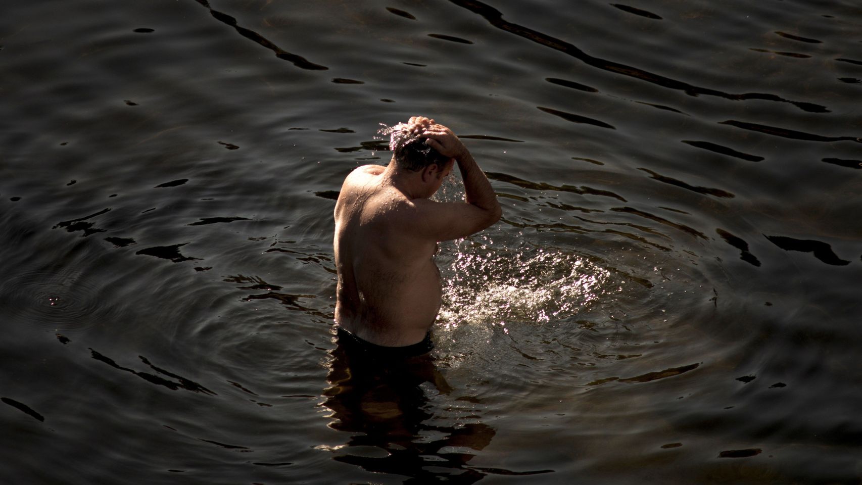 Un hombre se refresca en el Miño.