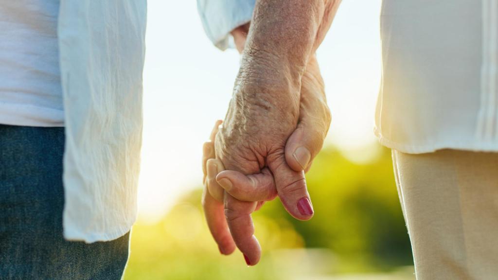 Pareja ancianos de la mano.