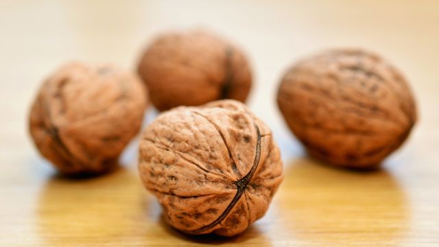 Unas nueces sin partir encima de una mesa.