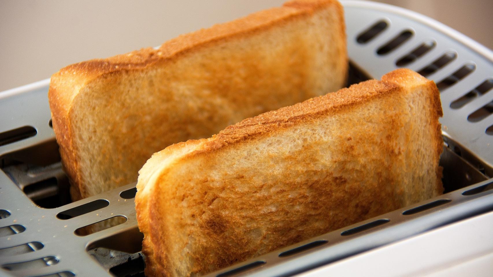 Un bocadillo de jamón de york recién cortado con un cuchillo.