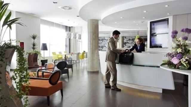 Un viajero de negocios haciendo el check-in en la recepción de un hotel.