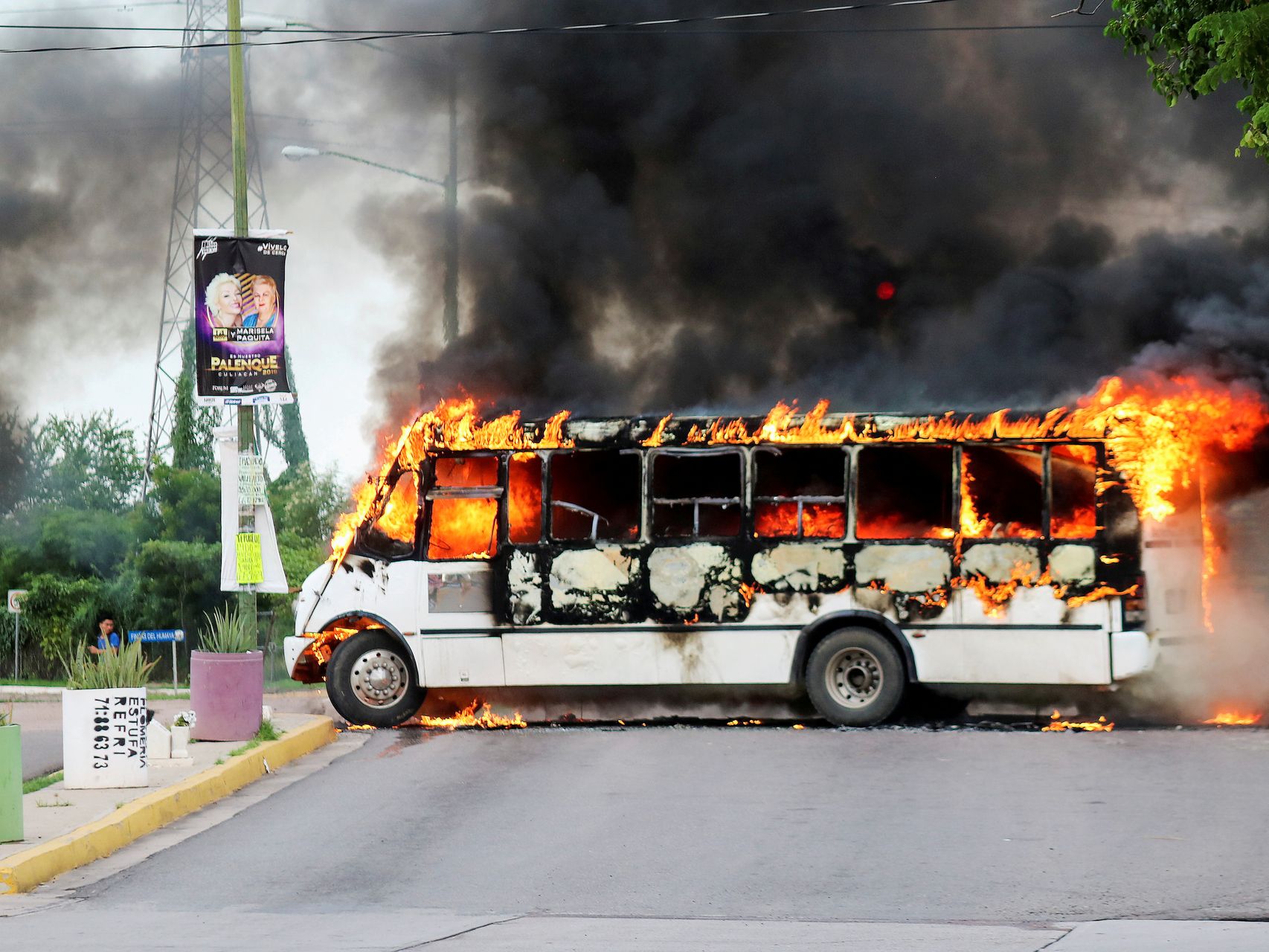 Un autobús ardiendo tras los enfrentamientos entre un cartel y la policía.