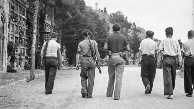 Fotografía de un grupo de milicianos que abandonan el cementerio de Montjuic (Barcelona) tras un entierro, en 1936, realizada por Antoni Campañá.