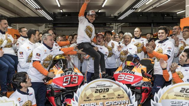 Marc Márquez coge en volandas a Jorge Lorenzo, en el box del equipo Repsol Honda.