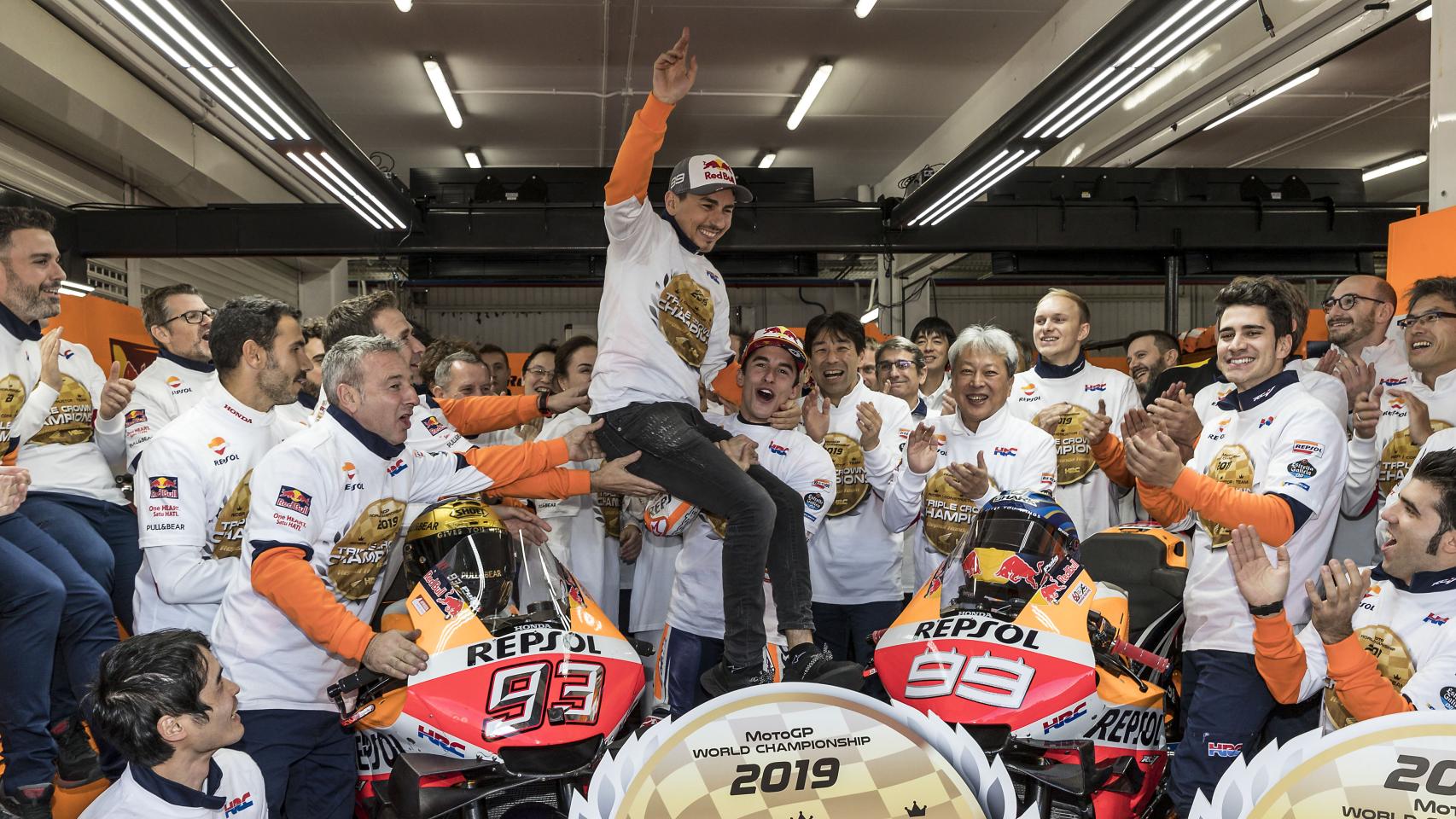 Marc Márquez coge en volandas a Jorge Lorenzo, en el box del equipo Repsol Honda.