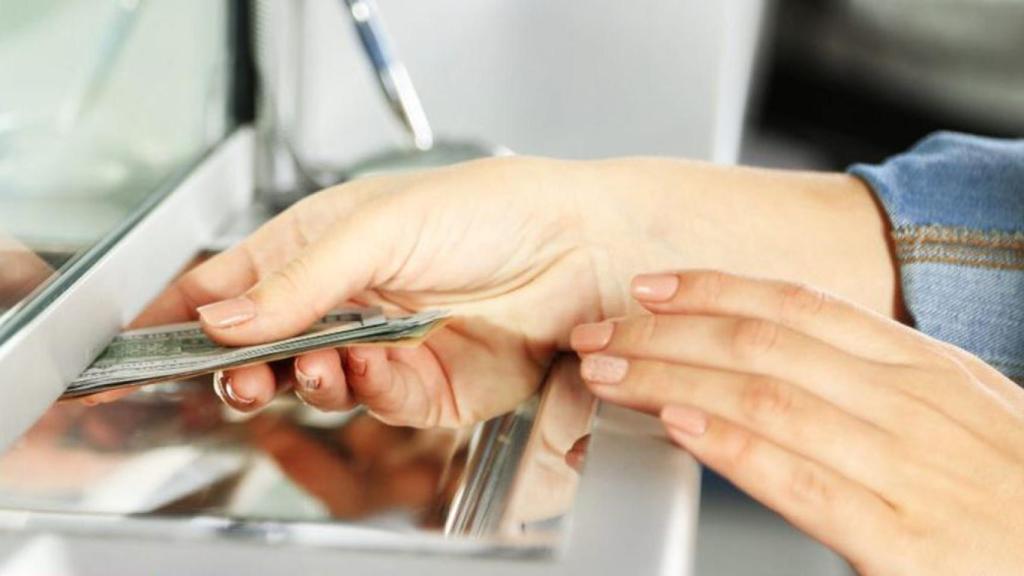 Mujer que retira dinero de un banco.