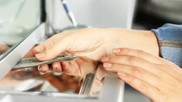 Mujer que retira dinero de un banco.
