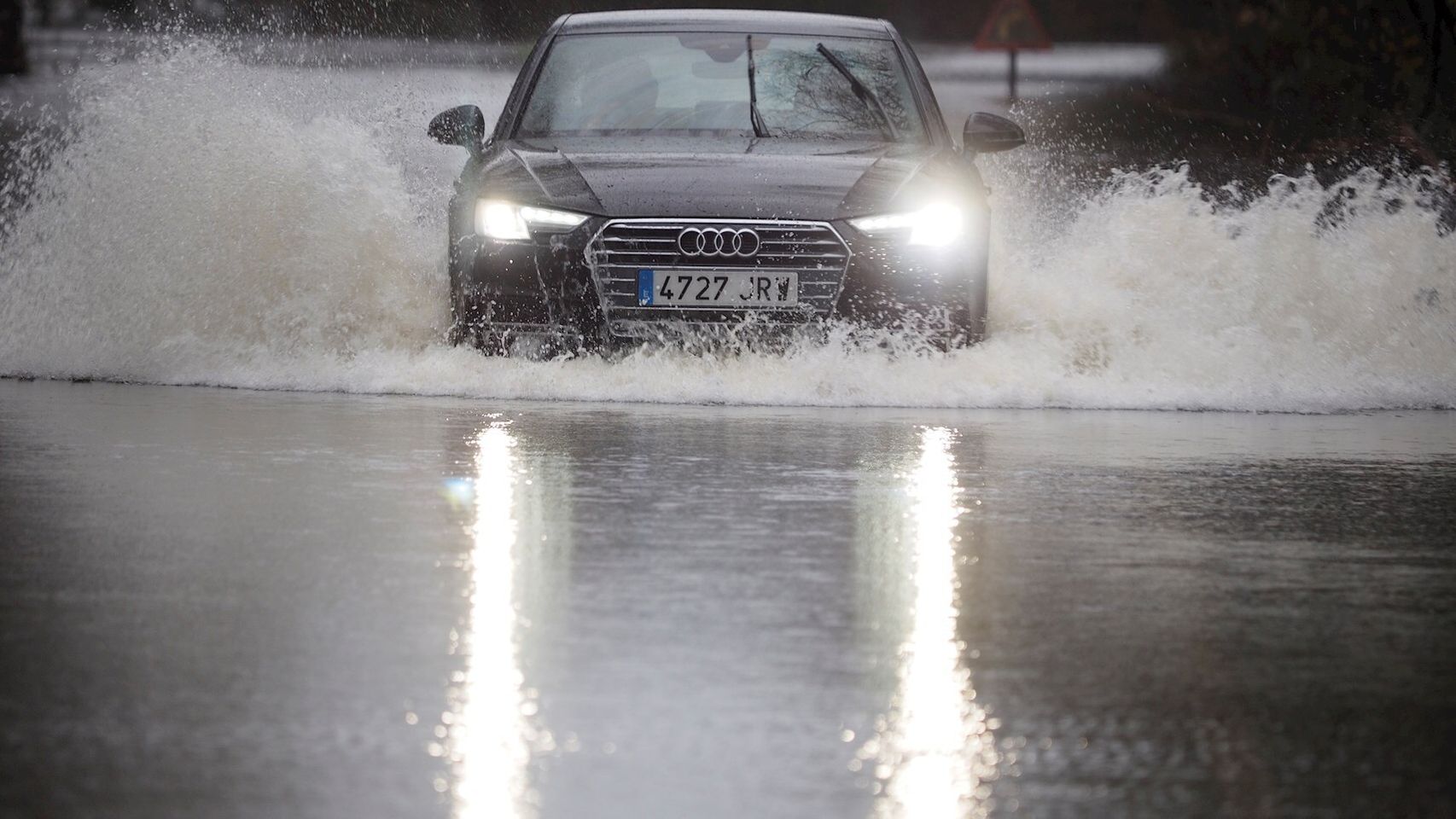 Un coche cruza la carretera LU-P-1701, en Muimenta, Lugo, inundada por el agua de los ríos Pequeño y Miño. EFE/ Eliseo Trigo