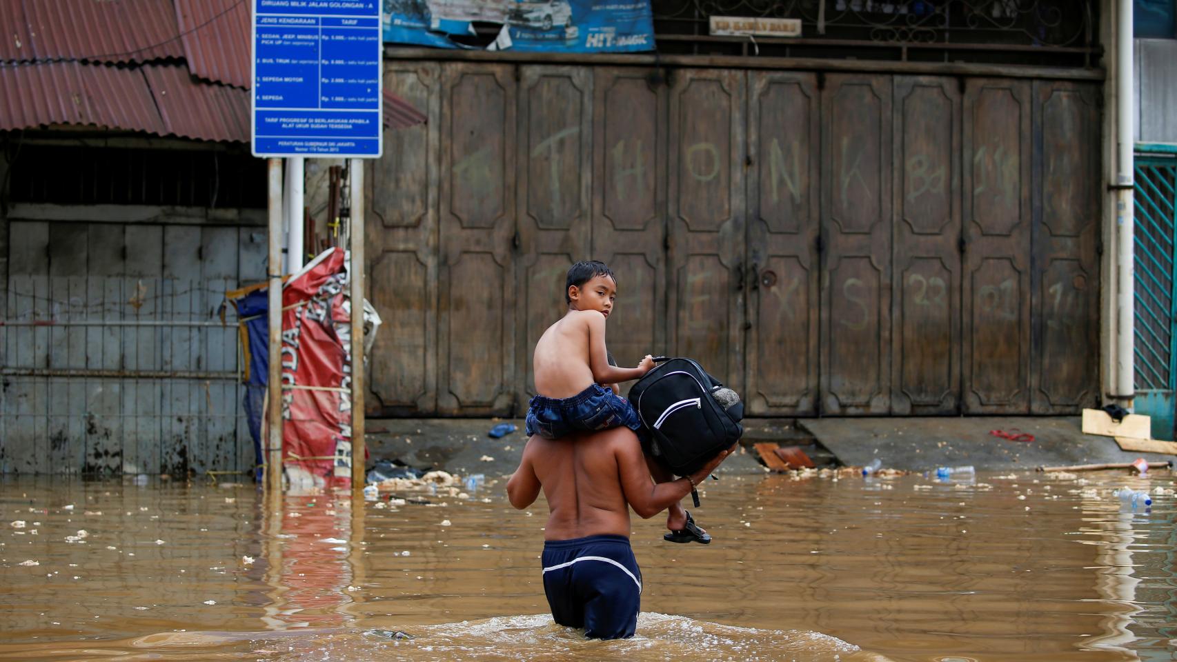 Un hombre camina por una zona anegada de indonesia.