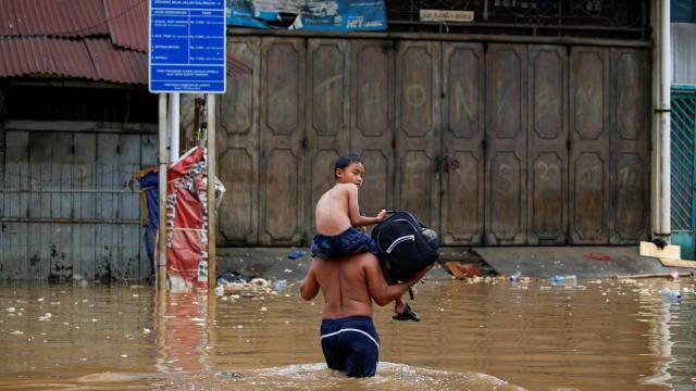 Un hombre camina por una zona anegada de indonesia.