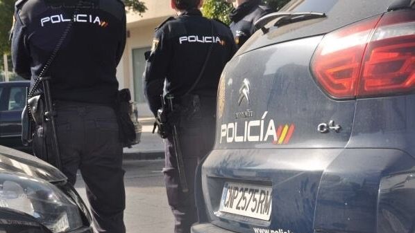 Agentes de la Policía Nacional, junto a sus coches.