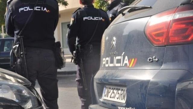 Agentes de la Policía Nacional,  junto a sus coches.