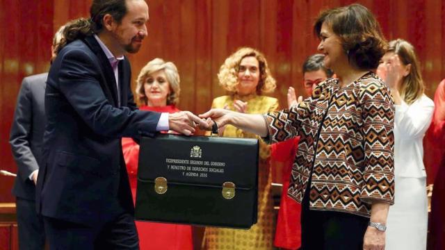 Pablo Iglesias recibe la cartera de la mano de Carmen Calvo.