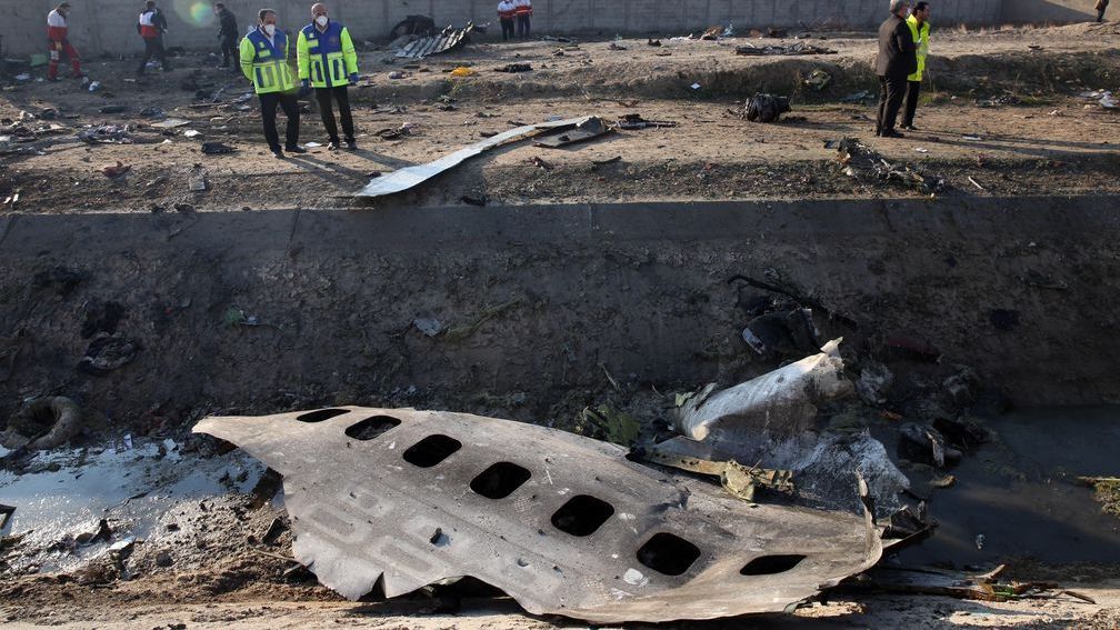 Miembros de los servicios de emergencia observan parte del fuselaje del Boeing 737 de la compañía ucraniana UIA que se estrelló en Teherán