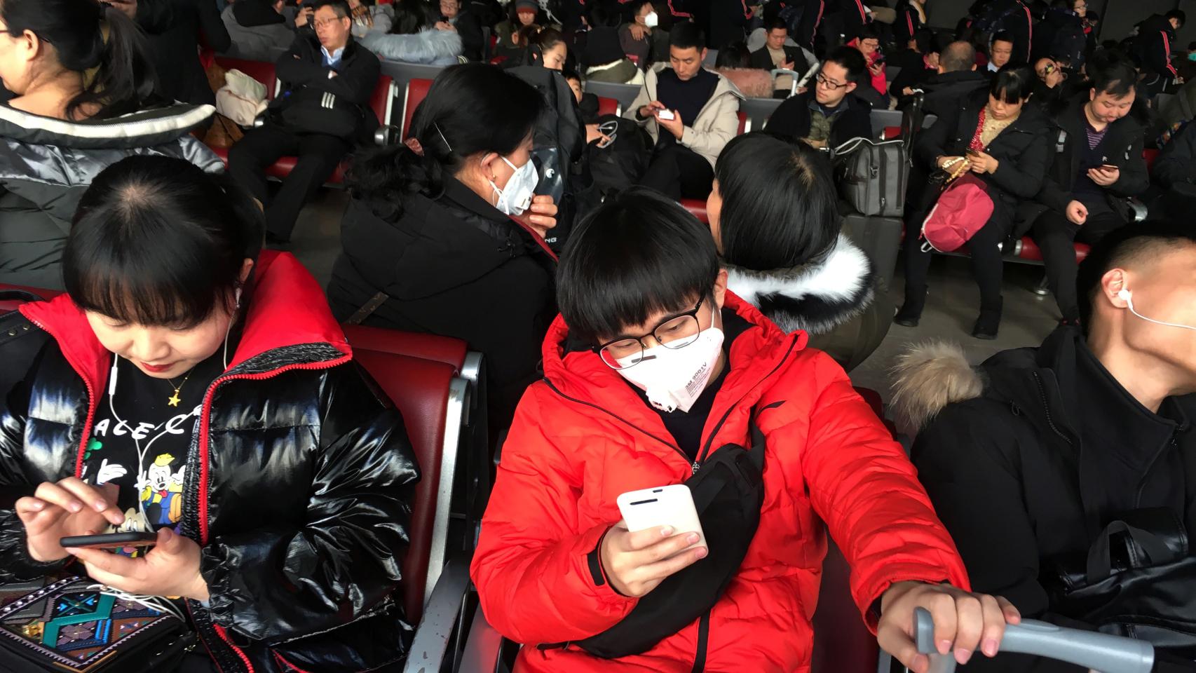Passengers wearing masks are seen at the waiting area for a train to Wuhan at the Beijing West Railway Station, in Beijing