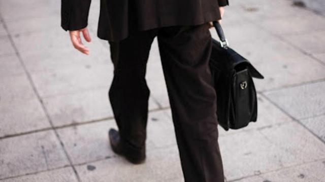 Un hombre pasea con un maletín.