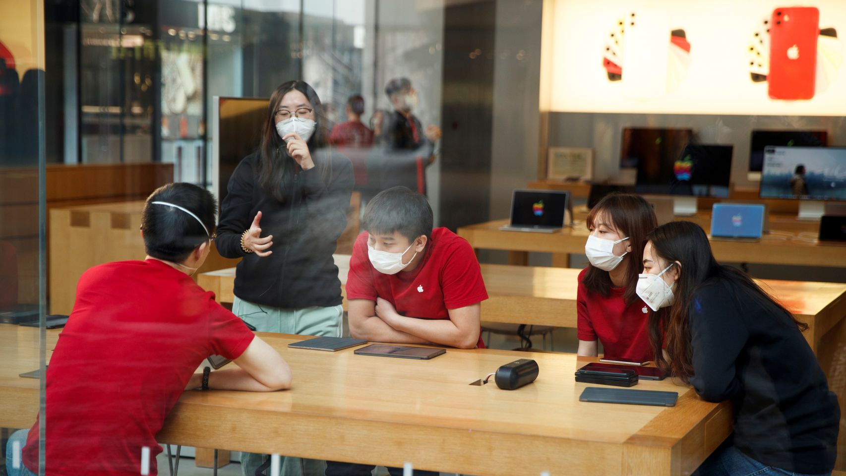 Jóvenes con mascarillas en una Apple Store en Beijing.