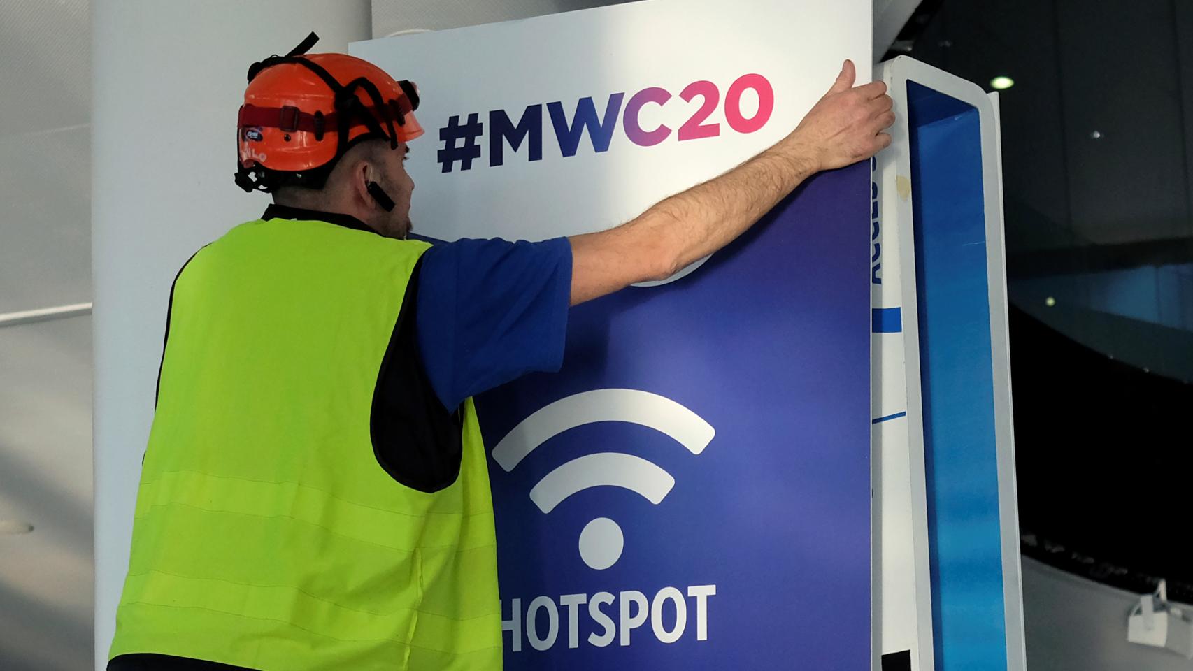 Un empleado coloca un cartel del Mobile de Barcelona