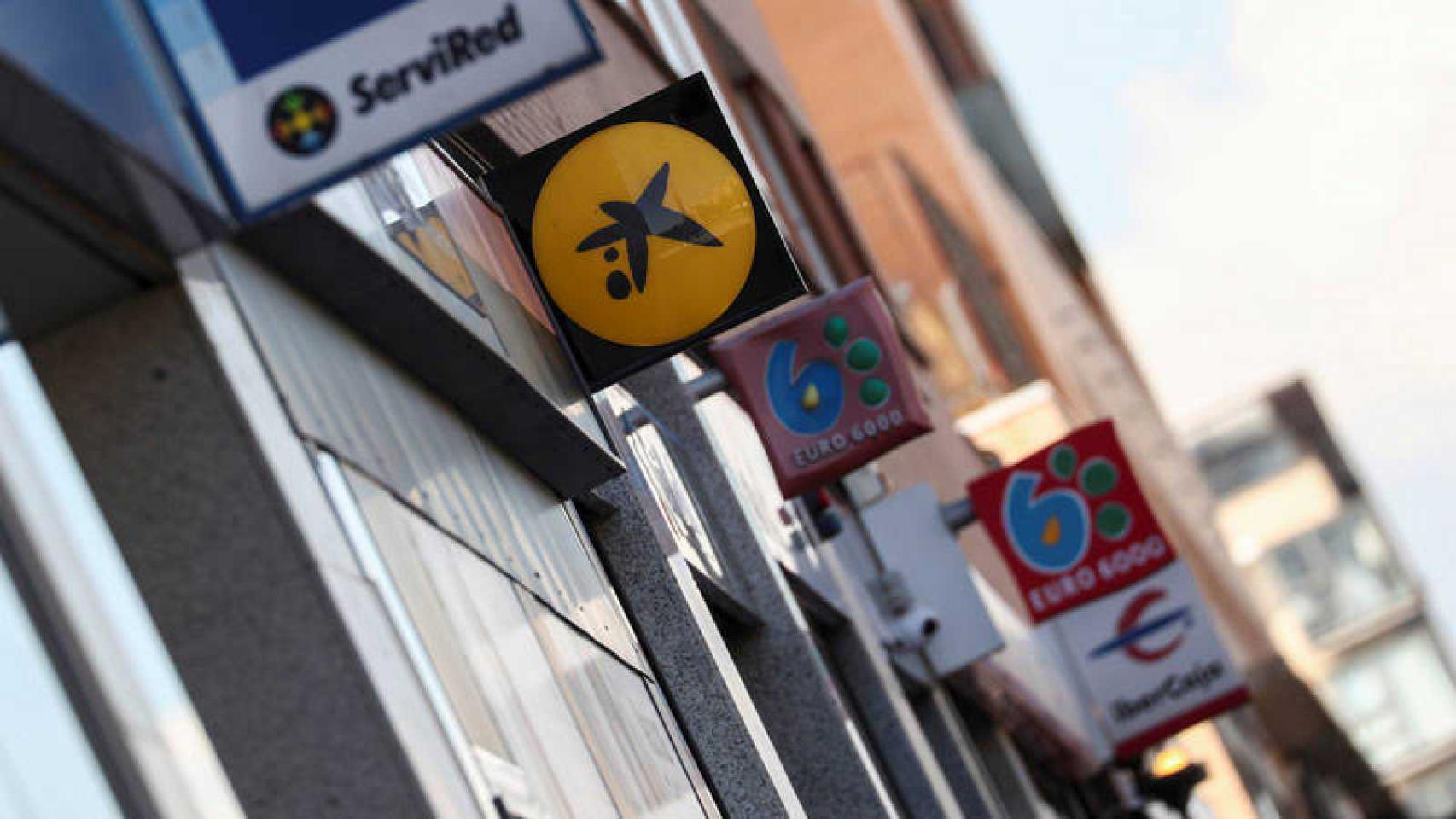 Rótulos de entidades financieras en una calle comercial.