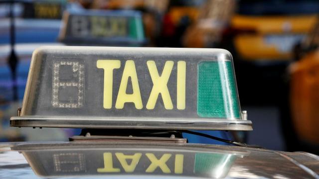 Un luminoso de taxi en una parada con muchos de estos vehículos.