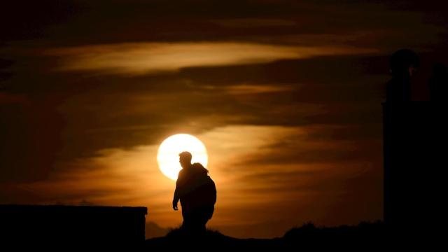 Dos personas pasean durante el atardecer en la localidad cántabra de Suances. EFE/ Pedro Puente Hoyos