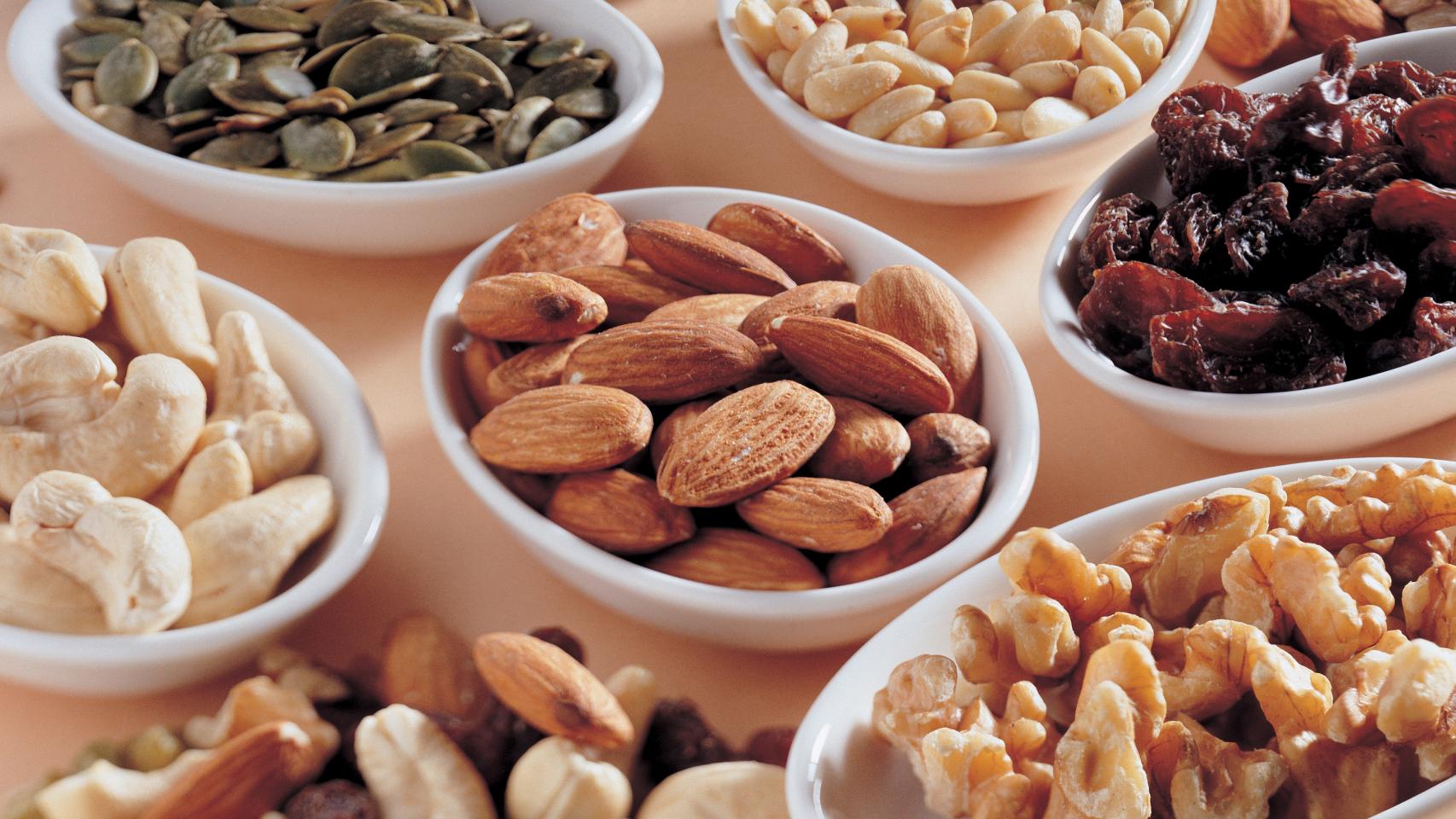 Varios cuencos con frutos secos, semillas y frutas deshidratadas.