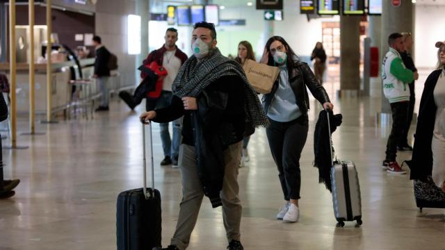 Pasajeros con mascarilla en un aeropuerto.