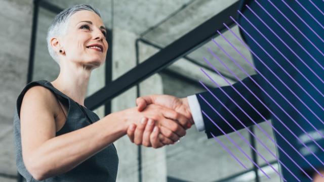 Una mujer directiva saluda a un trabajador.