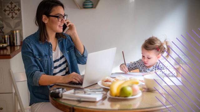 Una madre teletrabajando junto a su hija.