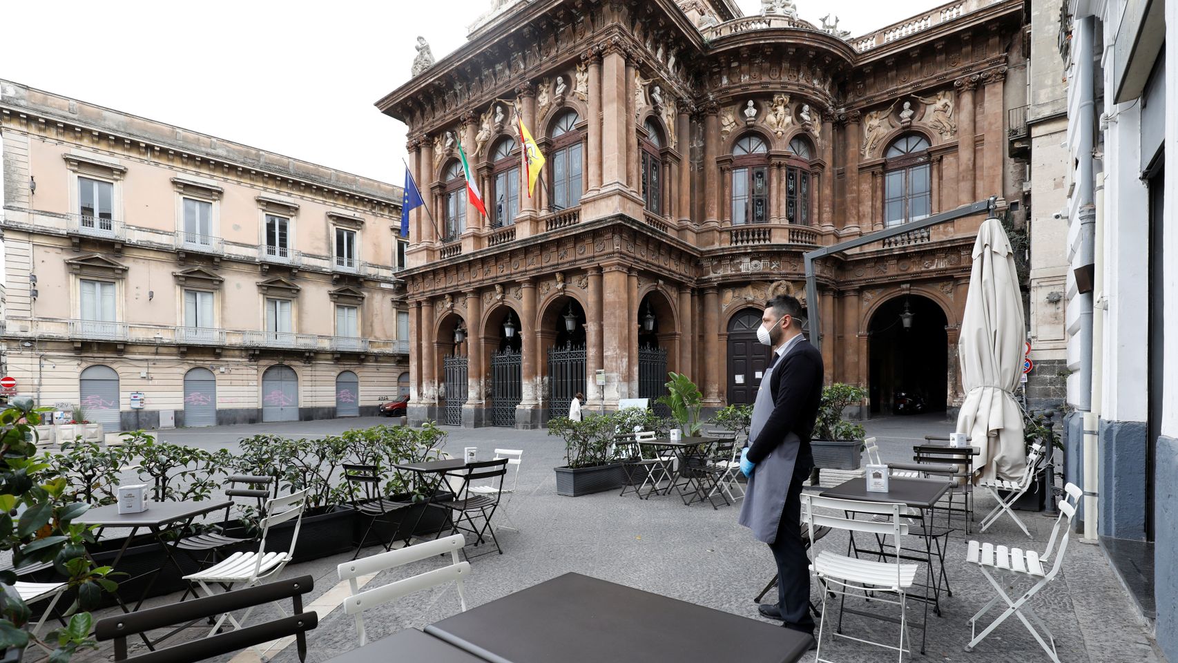 Un camarero espera clientes en la ciudad de Catania, Sicilia)