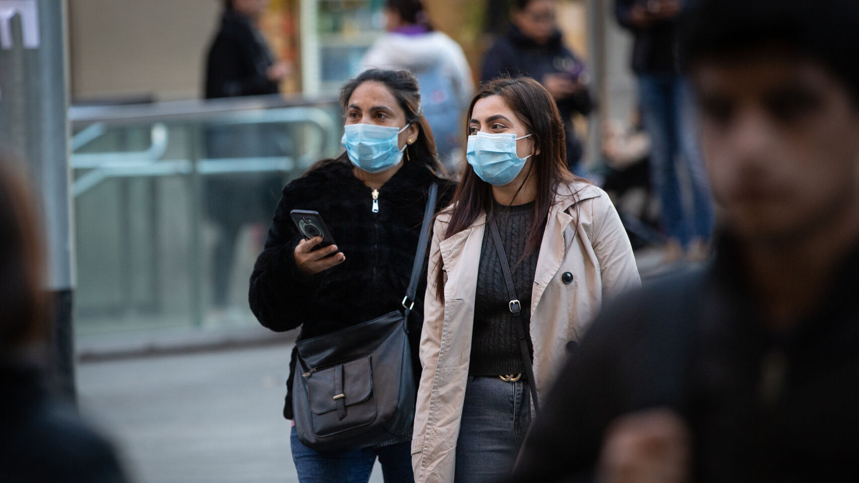 Dos mujeres pasean con mascarilla.