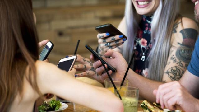 Comiendo con un smartphone en la mano.
