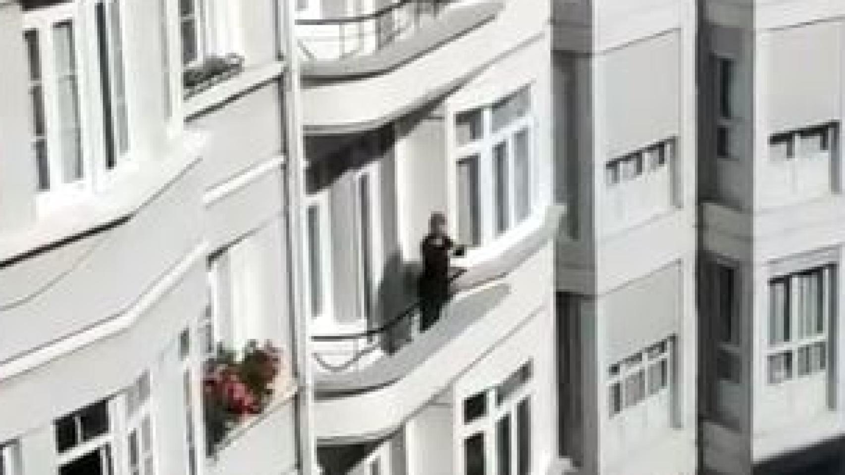 Una mujer, desde su ventana, secunda la cacerolada para que el Juan Carlos I dé los 100 millones saudíes a la Sanidad Pública.