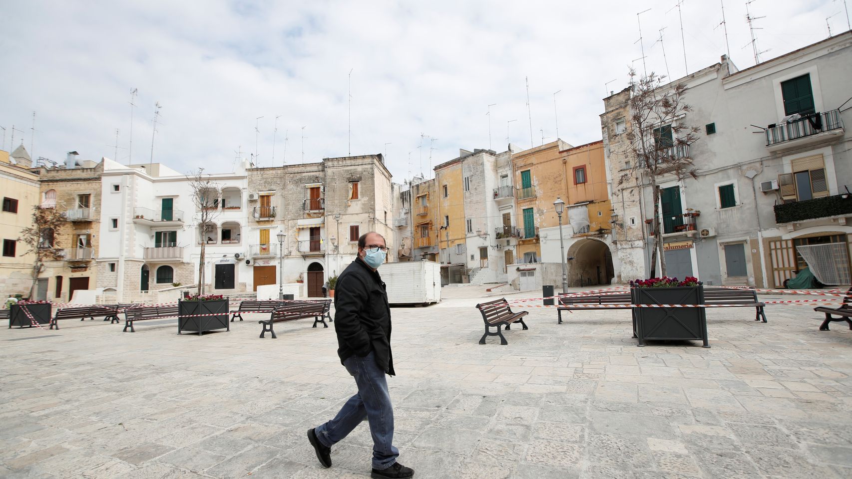 Un hombre pasea solo por la ciudad de Bari, Italia.