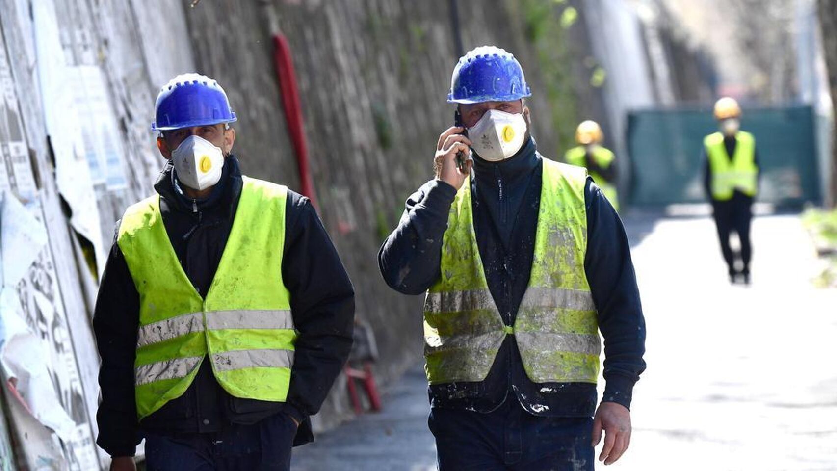 Dos operarios de obra con mascarilla.