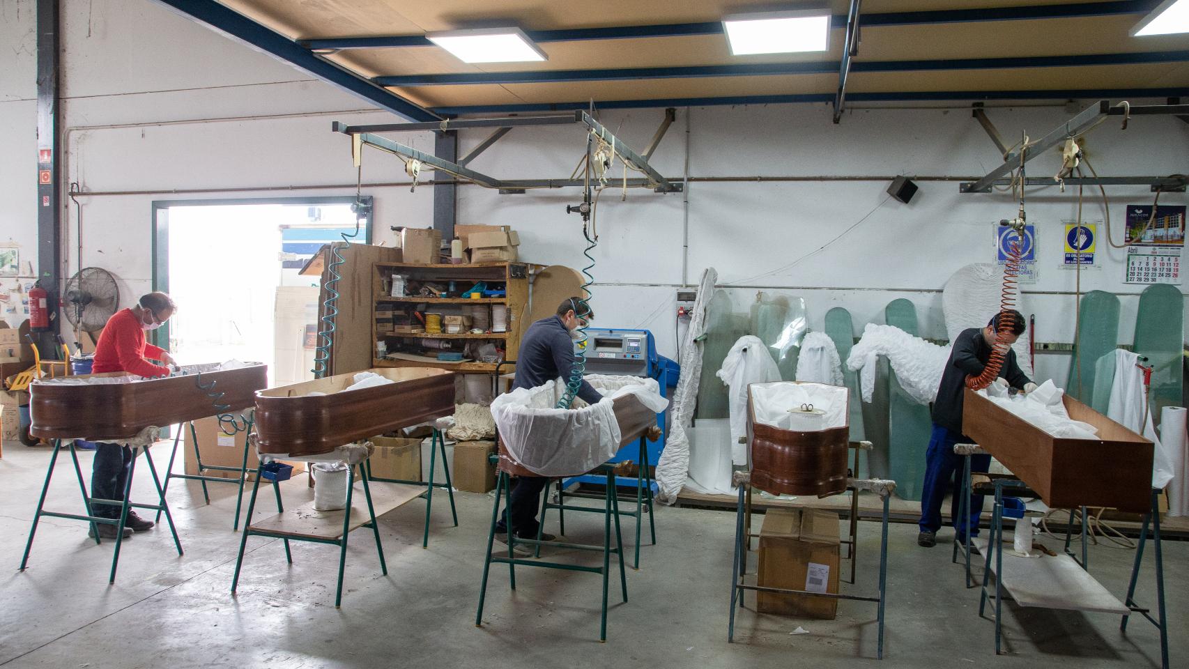 Varios empleados durante la última fase de producción de los ataúdes antes de su comercialización.